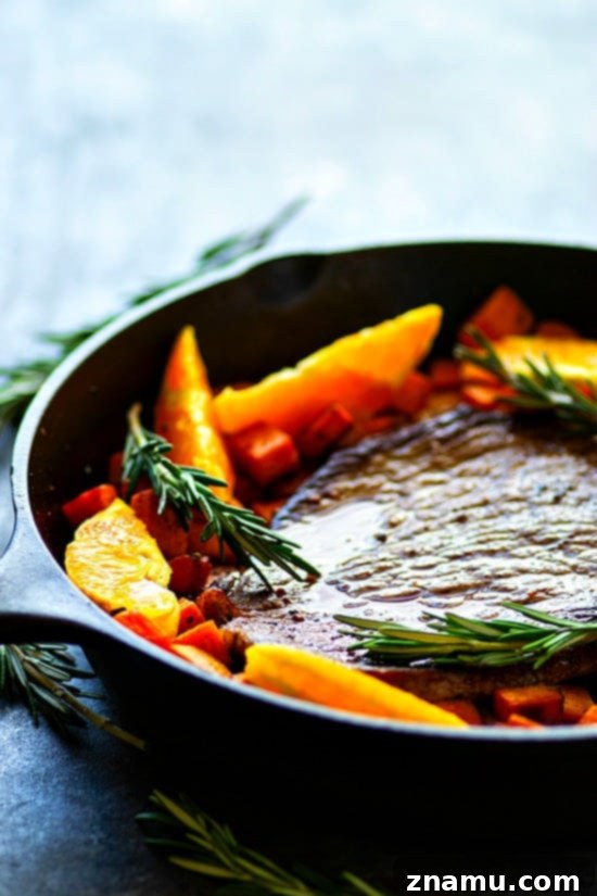 Close-up of One-Pan Orange Rosemary Steak with Sweet Potatoes - Juicy oranges and fragrant rosemary join forces in this weeknight-friendly one-pan orange rosemary steak roasted with tender sweet potatoes in an incredible orange rosemary sauce!