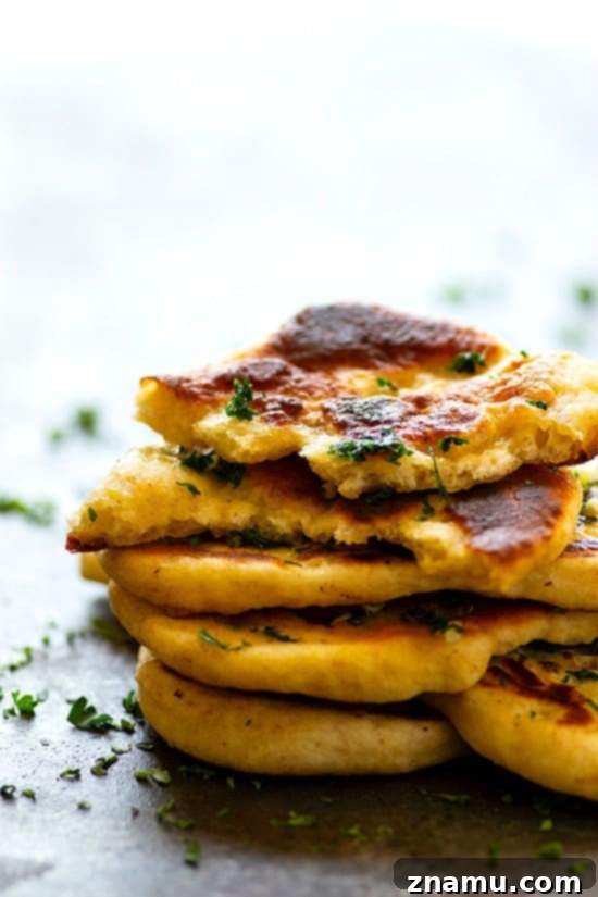 Restaurant-Style Garlic Herb Naan Bread - Impossibly soft and pillowy restaurant-style garlic herb naan bread is SUPER easy to make at home and the best side to any curry or rice dish!