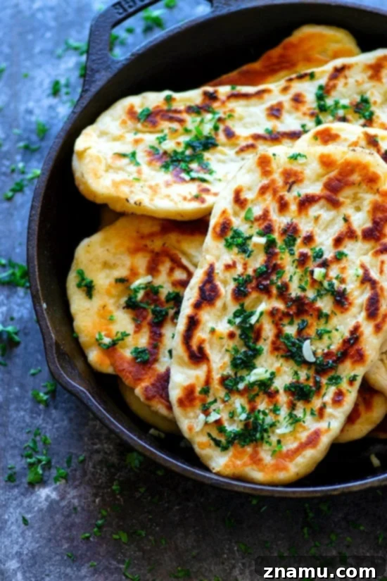 Restaurant-Style Garlic Herb Naan Bread - Impossibly soft and pillowy restaurant-style garlic herb naan bread is SUPER easy to make at home and the best side to any curry or rice dish!