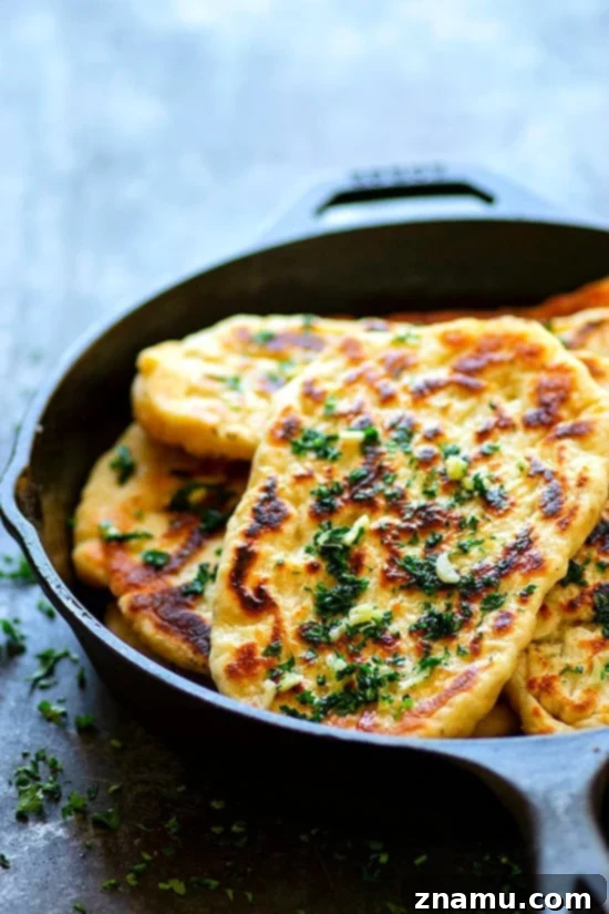 Restaurant-Style Garlic Herb Naan Bread - Impossibly soft and pillowy restaurant-style garlic herb naan bread is SUPER easy to make at home and the best side to any curry or rice dish!