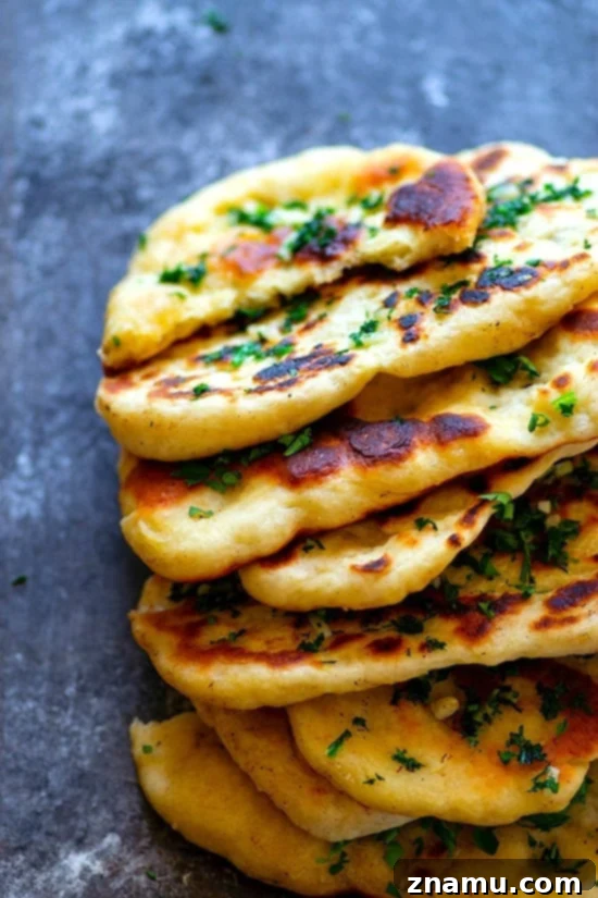 Restaurant-Style Garlic Herb Naan Bread - Impossibly soft and pillowy restaurant-style garlic herb naan bread is SUPER easy to make at home and the best side to any curry or rice dish!