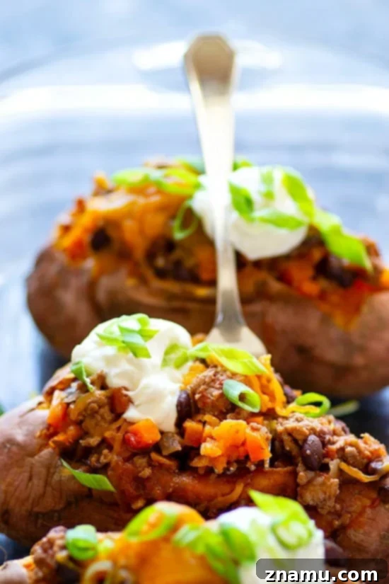 Loaded Turkey Chili Sweet Potato Boats 5 Close-up of freshly broiled Turkey Chili Twice-Baked Sweet Potatoes, showing golden-brown melted cheese.