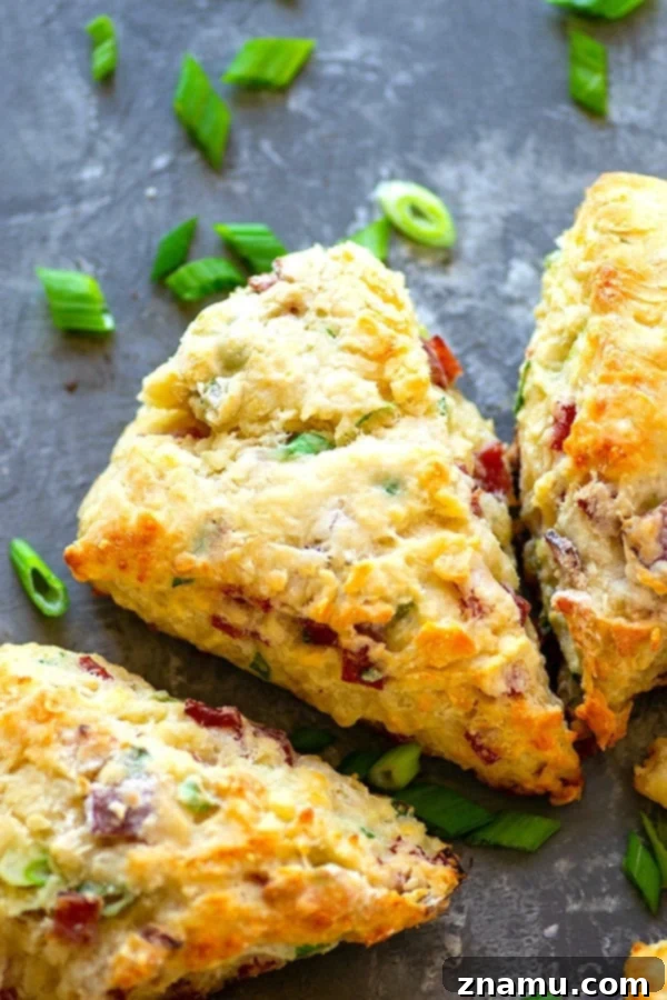 Savory White Cheddar Bacon Scallion Scones 5 Five delicious White Cheddar Bacon Scallion Scones arranged on a serving plate, steaming hot and ready to eat.