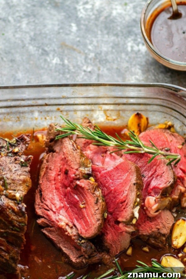Rosemary Garlic Butter Beef Tenderloin - Roasted to perfection in a flavorful rosemary garlic butter and covered in hearty red wine sauce, this rosemary garlic butter beef tenderloin is an easy, yet impressive entree for any dinner crowd.