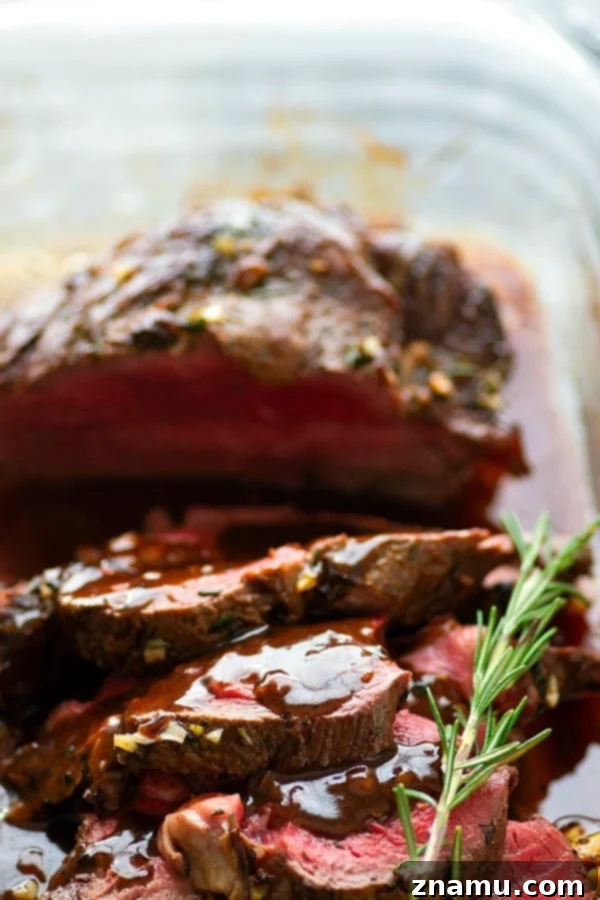 Rosemary Garlic Butter Beef Tenderloin - Roasted to perfection in a flavorful rosemary garlic butter and covered in hearty red wine sauce, this rosemary garlic butter beef tenderloin is an easy, yet impressive entree for any dinner crowd.