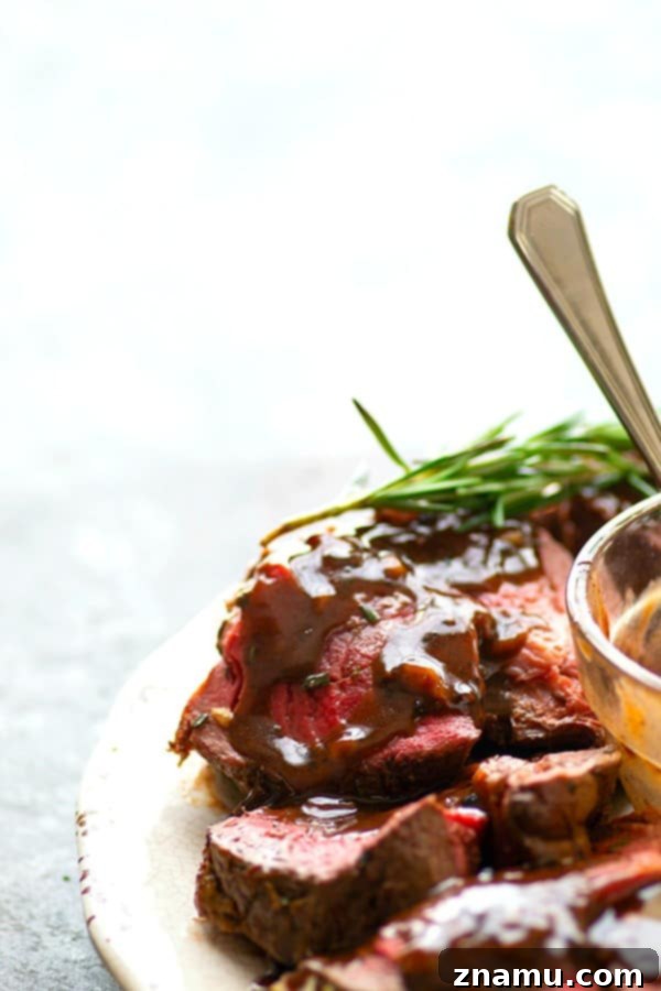 Rosemary Garlic Butter Beef Tenderloin - Roasted to perfection in a flavorful rosemary garlic butter and covered in hearty red wine sauce, this rosemary garlic butter beef tenderloin is an easy, yet impressive entree for any dinner crowd.