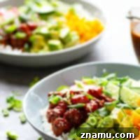 Spicy Ginger Mango Salmon Poke Bowls - A spicy ginger sauce, sweet fresh mango, and tons of veggie goodness are piled into these healthy salmon poke bowls that are SUPER easy to make at home for a fraction of the restaurant cost!