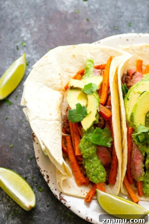 Jerk Sweet Potato Tacos with Zesty Avocado Tomatillo Salsa 3 Jerk Sweet Potato Steak Tacos - Close-up of a loaded Jerk Sweet Potato Steak Taco with perfectly cooked steak, roasted sweet potatoes, and a generous topping of fresh avocado salsa verde, cilantro, and avocado slices.