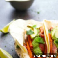 Jerk Sweet Potato Steak Tacos - Jerk-rubbed steak and roast sweet potatoes are piled into soft flour tortillas and topped with a creamy avocado salsa verde for an incredible twist on sweet potato steak tacos!