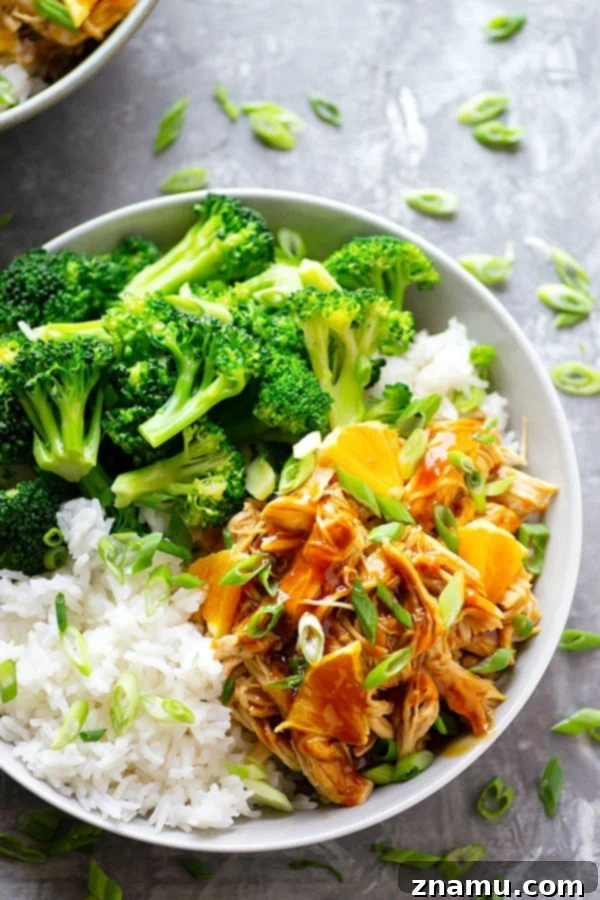 Delicious and saucy Instant Pot Orange Chicken piled high into a rice bowl with steamed broccoli and orange wedges, ready to be enjoyed as a healthy Chinese takeout alternative.