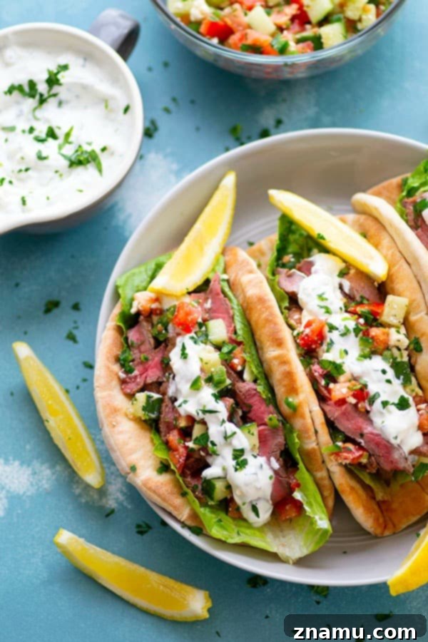 Savory Grilled Steak Gyros with Bright Feta-Cucumber Salsa and Cool Tzatziki 2 Juicy grilled steak gyros stacked high with fresh toppings on a soft pita bread