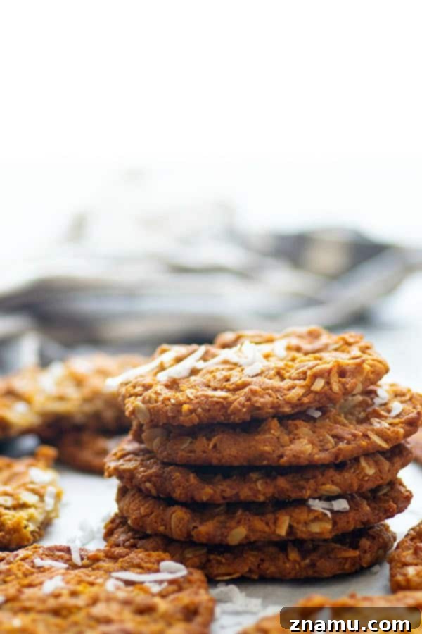 Freshly baked Anzac Biscuits cooling on a wire rack.