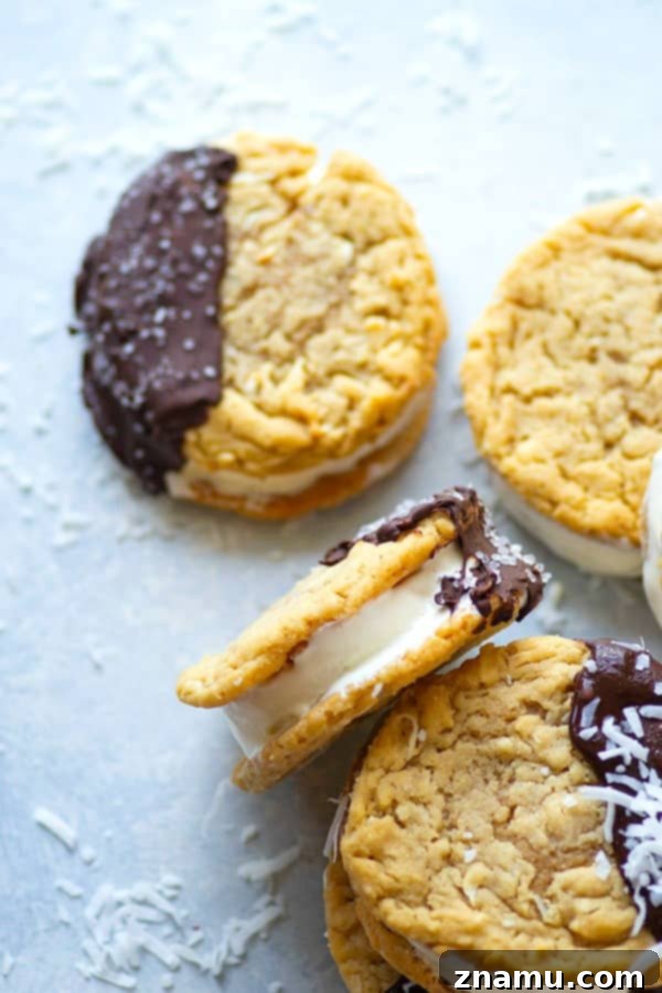 Decadent Chocolate Coconut Peanut Butter Ice Cream Treats 3 Freshly made chocolate-dipped coconut peanut butter ice cream sandwiches arranged on a baking sheet