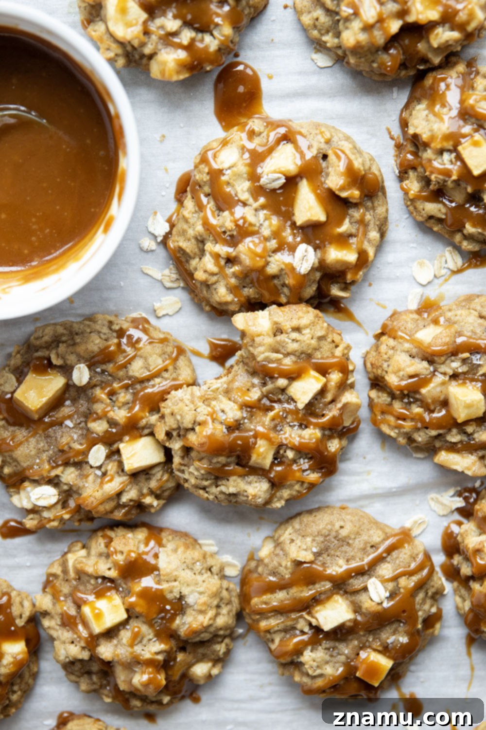 Salted Caramel Apple Oatmeal Cookies 4 Overhead shot of freshly baked caramel apple oatmeal cookies on parchment paper
