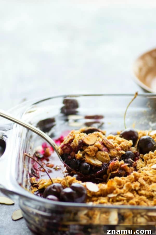 Perfectly baked blueberry cherry crisp, cooling on a rack, ready to be served warm with vanilla ice cream.