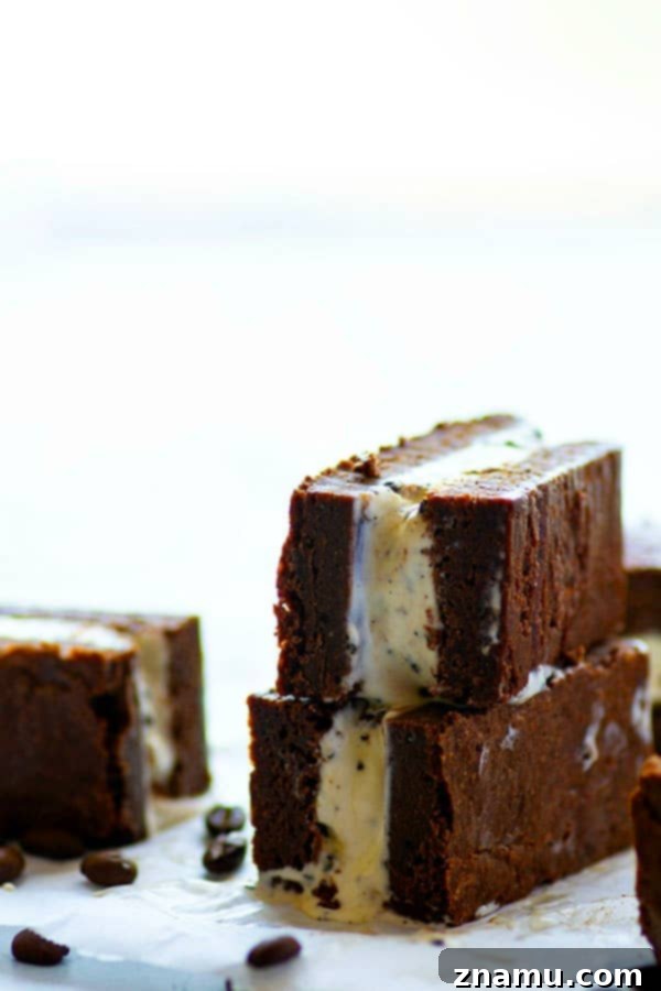 Decadent Espresso Peanut Butter Brownie Ice Cream Sandwiches 5 Four assembled brownie ice cream sandwiches on parchment paper, showcasing the rich colors of brownie, espresso ice cream, and peanut butter.