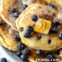 A small image showing a stack of blueberry cornmeal pancakes.