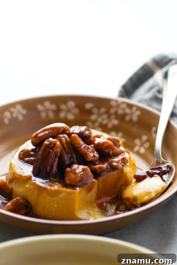 Autumn Spice Panna Cotta with Salted Pecan Caramel 5 A serving of pumpkin panna cotta, removed from its ramekin, lavishly covered with salted caramel pecan sauce and chopped pecans, presented on a white plate.