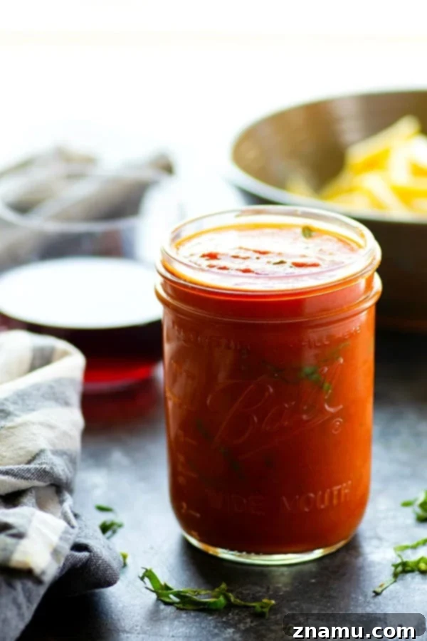Effortless Red Wine Pasta Sauce 2 A vibrant bowl of pasta generously coated with homemade red wine pasta sauce, garnished with fresh basil leaves.