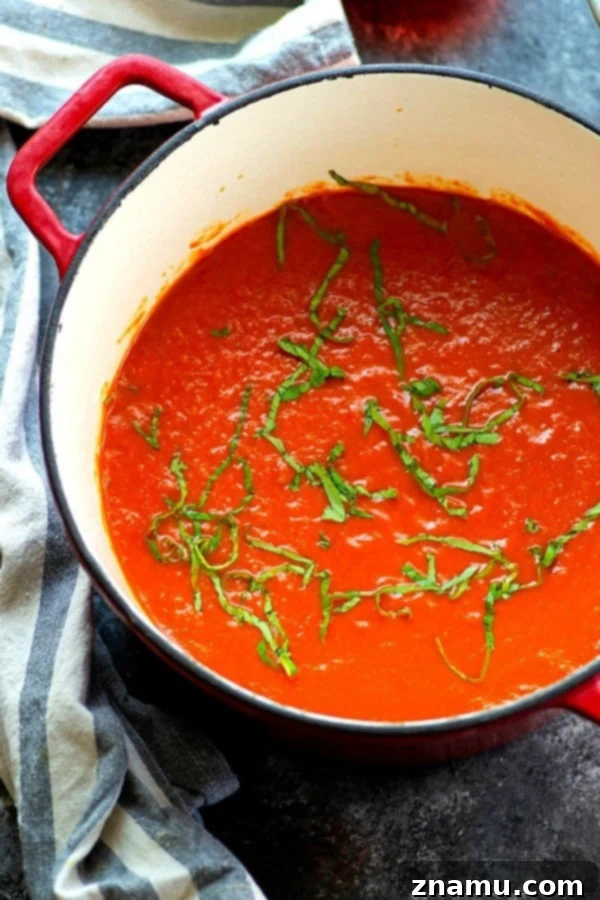 Effortless Red Wine Pasta Sauce 4 A wooden spoon stirring a pot of deeply colored red wine pasta sauce, highlighting its thick consistency.