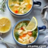 A hearty bowl of Turkey Orzo Kale White Bean Soup, garnished with fresh herbs.
