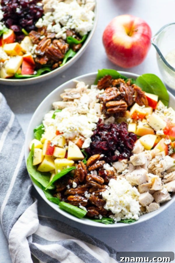 The Golden Harvest Turkey & Candied Pecan Salad 3 Close-up of a loaded autumn salad featuring turkey, apples, spinach, and candied pecans.