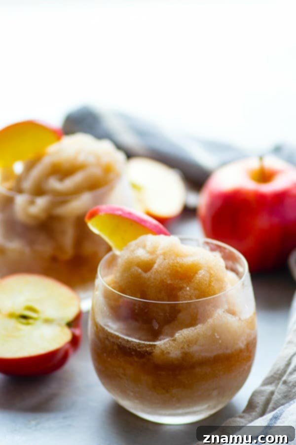 Autumn Bourbon Apple Freeze 5 A glass of Apple Cider Bourbon Slushie with a cinnamon stick garnish, presented on a rustic wooden surface, capturing the autumn mood.