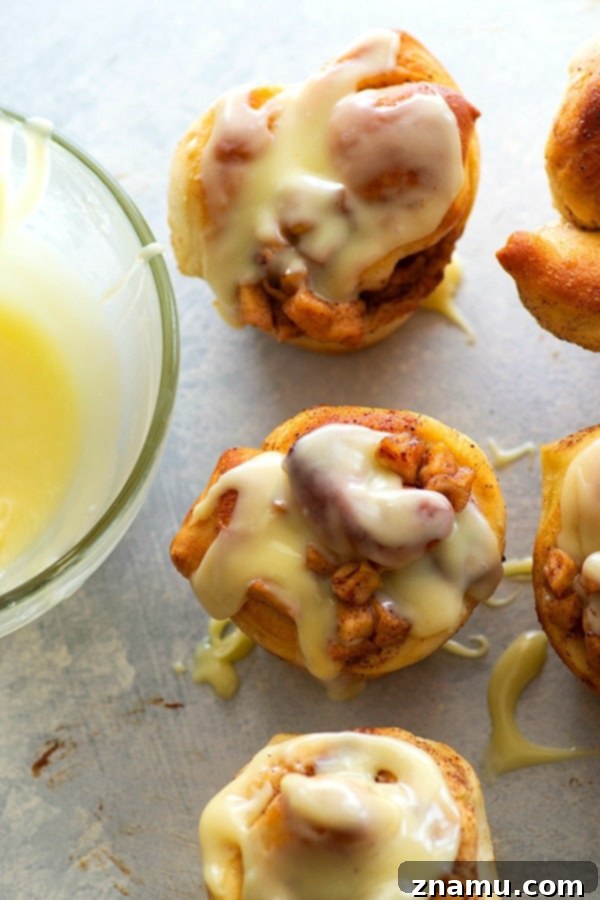 Fluffy cinnamon roll muffins are stuffed with a caramelized apple filling and glazed in a sweet white chocolate glaze for a dreamy fall breakfast!