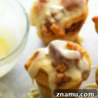 Fluffy cinnamon roll muffins are stuffed with a caramelized apple filling and glazed in a sweet white chocolate glaze for a dreamy fall breakfast!