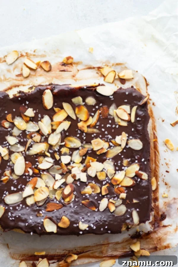 Decadent Chocolate Ganache Almond Sugar Cookie Bars 3 Close-up of golden brown almond sugar cookie bars, freshly baked and ready for chocolate ganache topping. A simple yet elegant dessert.