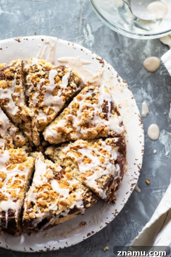 Brown Butter Gingerbread Crumb Coffee Cake 3 A close-up shot of a slice of browned butter gingerbread coffee cake on a plate, showcasing its soft, moist texture, visible streusel, and delicate glaze drizzle, ideal for a Christmas morning.