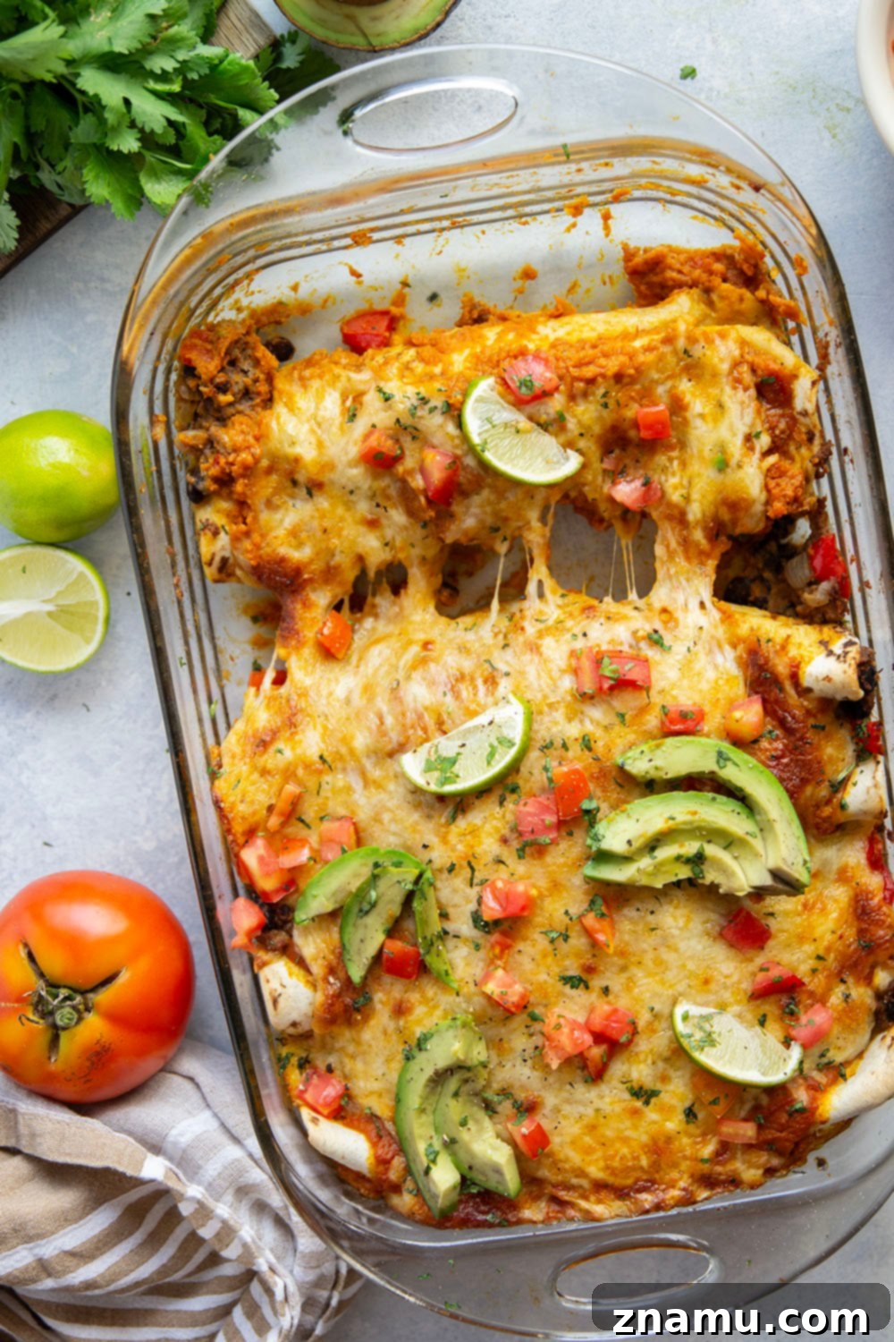 Golden Pumpkin Enchiladas 6 A serving of pumpkin enchiladas garnished with fresh cilantro and avocado slices on a plate.