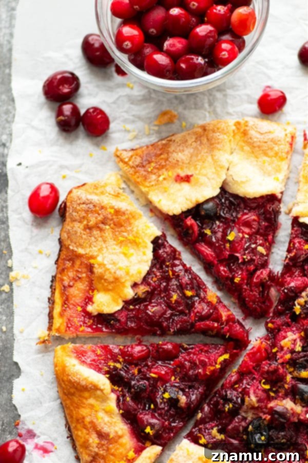Ginger-Kissed Orange & Cranberry Galette 2 Rustic Orange Ginger Cranberry Galette on a baking sheet, showcasing a golden, flaky crust and bubbling cranberry filling with orange zest and ginger.