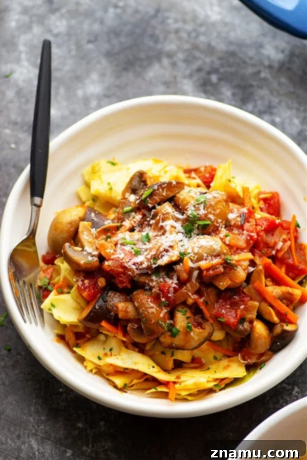 Close-up of shiitake mushroom ragu with fresh herbs and pasta, a delectable vegetarian dish