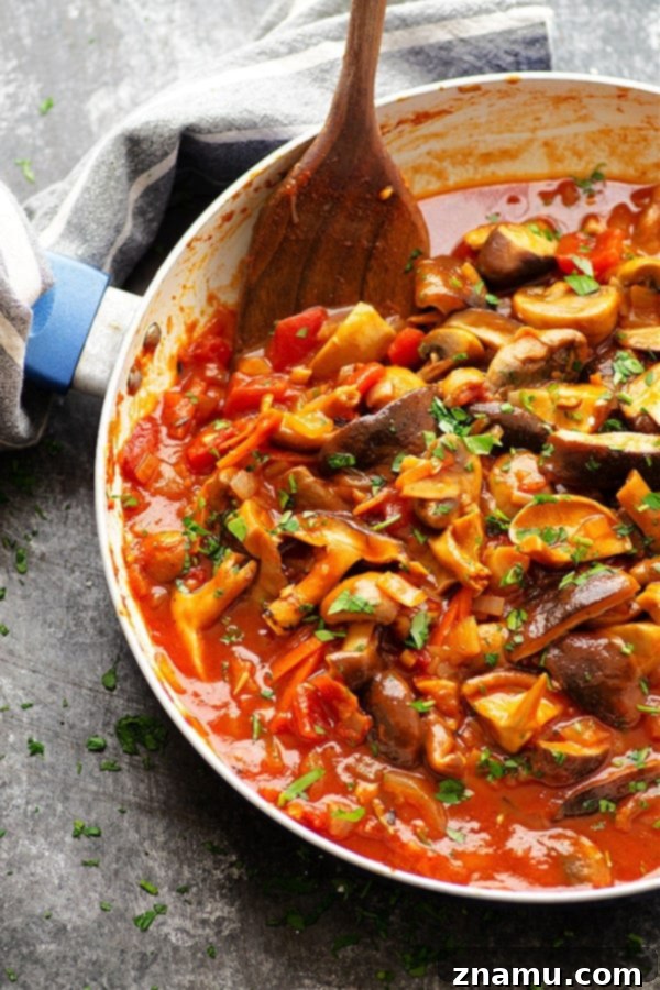 Serving of shiitake mushroom ragu with grated Parmesan cheese over pappardelle
