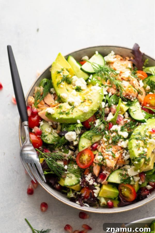 Smoky Salmon and Creamy Avocado Salad with Tangy Honey Dijon 3 Close-up of Smoked Salmon and Avocado Salad showcasing its vibrant colors and fresh ingredients, including cherry tomatoes, cucumber, feta, and dill.