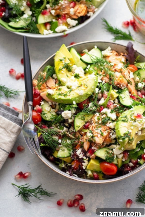 Smoky Salmon and Creamy Avocado Salad with Tangy Honey Dijon 5 A serving of Smoked Salmon and Avocado Salad, beautifully plated with pomegranate seeds and fresh dill, ready to be enjoyed.