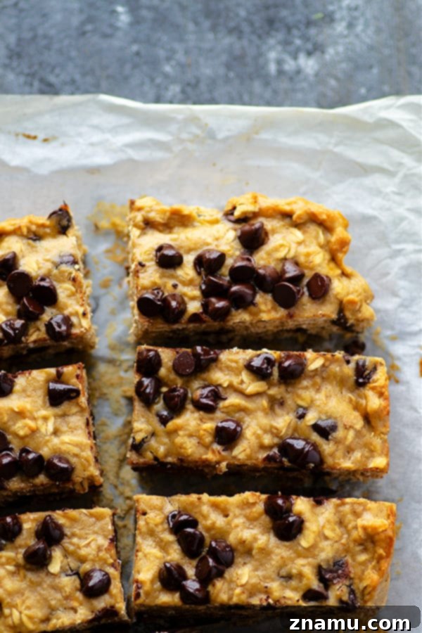Close-up of a stack of thick, chewy banana chocolate chip oatmeal breakfast bars, ready to eat.