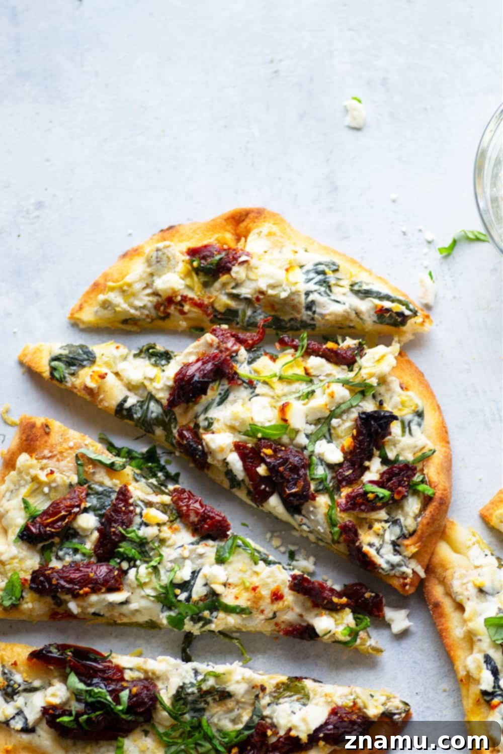 Vibrant Spinach Artichoke Flatbread with Sun-Kissed Tomatoes and Feta 3 Close-up of spinach artichoke flatbread showing the creamy texture and vibrant toppings.