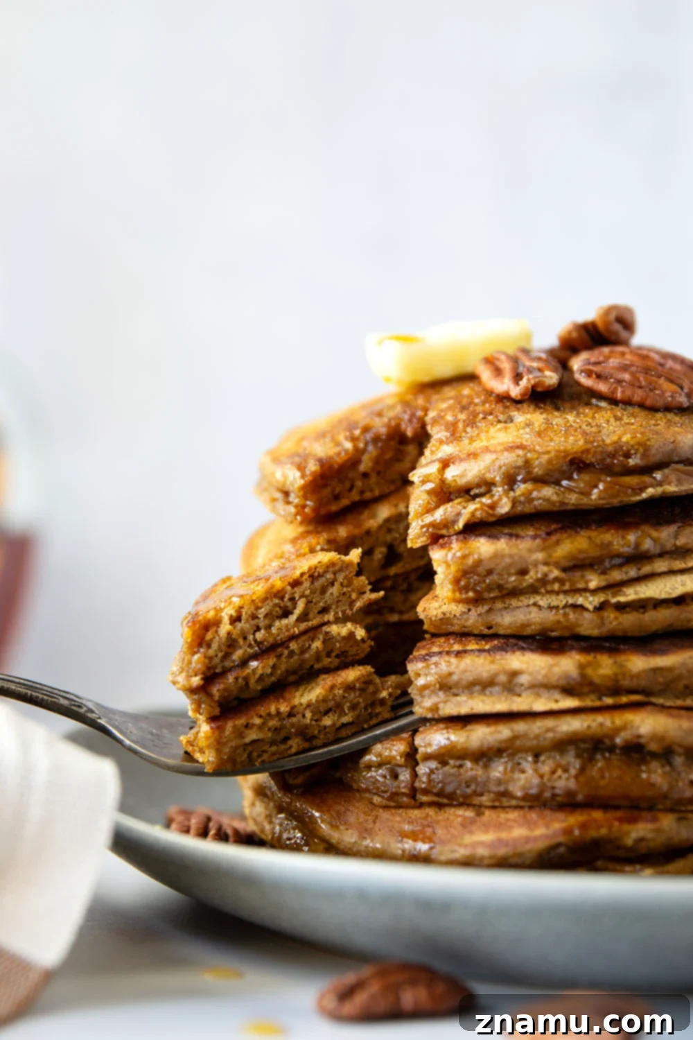 Cozy Gingerbread Pancakes 2 Thick and fluffy gingerbread pancakes topped with pecans and maple syrup, perfect for a holiday breakfast.