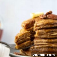 These thick and fluffy gingerbread pancakes taste exactly like a sweet and spicy gingerbread cake! Top warm pancakes with pecans and lots of maple syrup for a holiday breakfast treat.