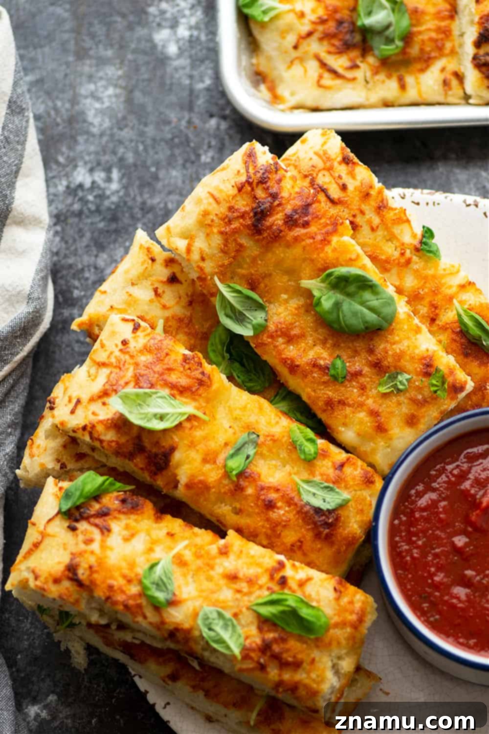 Savory Cheese Focaccia Sticks 4 Ingredients laid out for making Cheesy Pizza Focaccia Breadsticks, including flour, yeast, olive oil, and fresh basil.