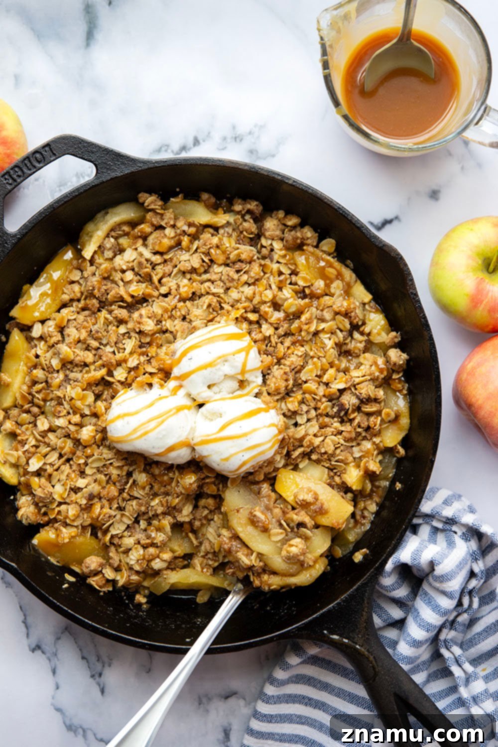 Gooey Skillet Caramel Apple Crisp 2 Warm Skillet Caramel Apple Crisp with a scoop of vanilla ice cream melting on top, garnished with extra caramel drizzle.