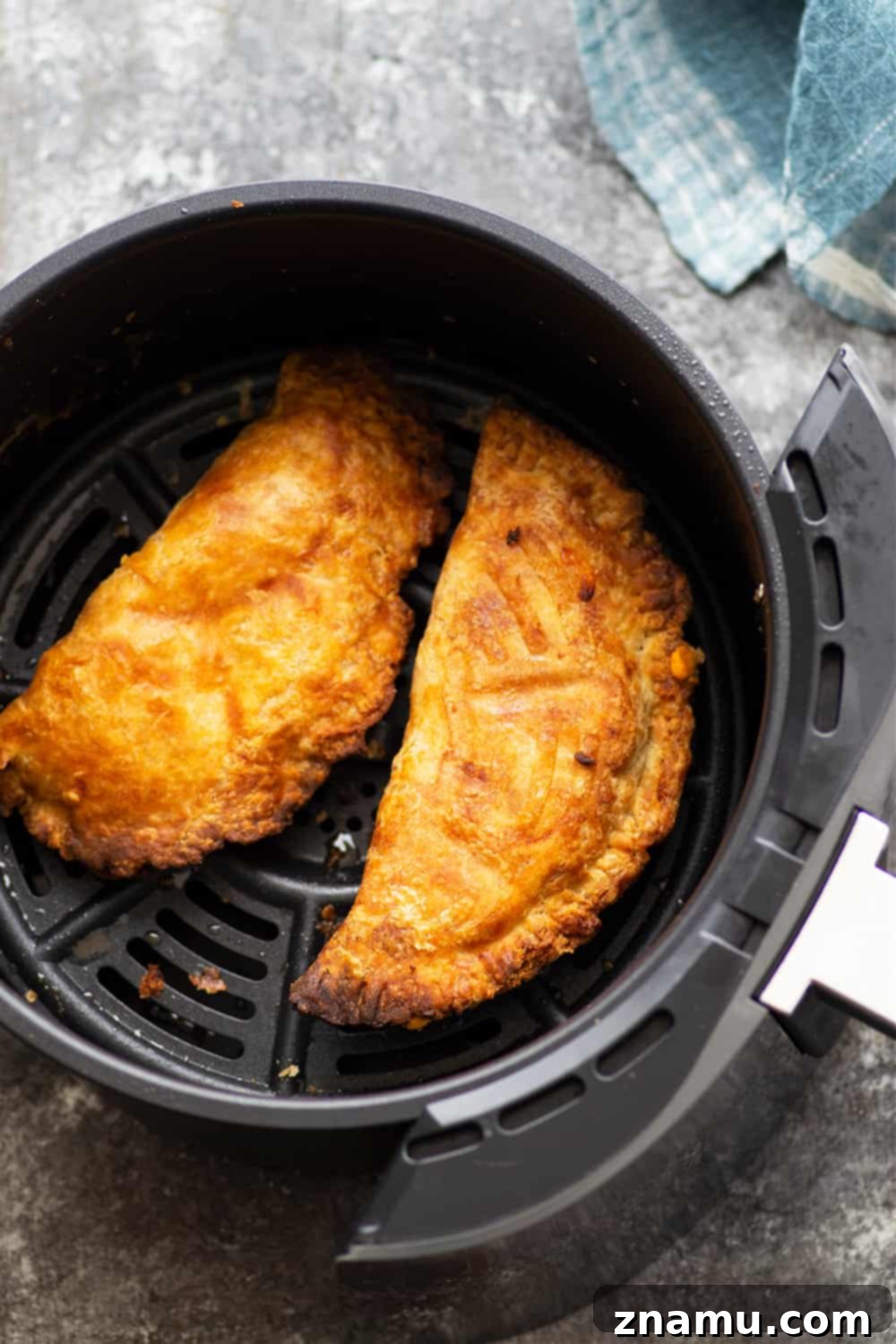 Crispy Air-Fried Buffalo Chicken Empanadas 3 Close-up of a perfectly cooked, flaky Air Fryer Buffalo Chicken Empanada revealing the spicy chicken filling.