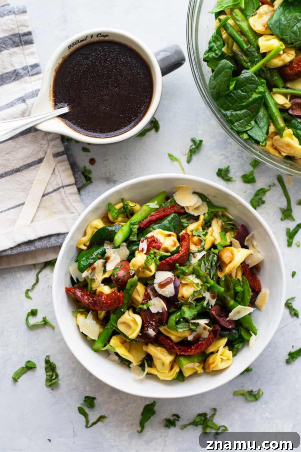 Vibrant Tuscan Tortellini Salad with sun-dried tomatoes, spinach, and honey balsamic dressing, perfect for meal prep.