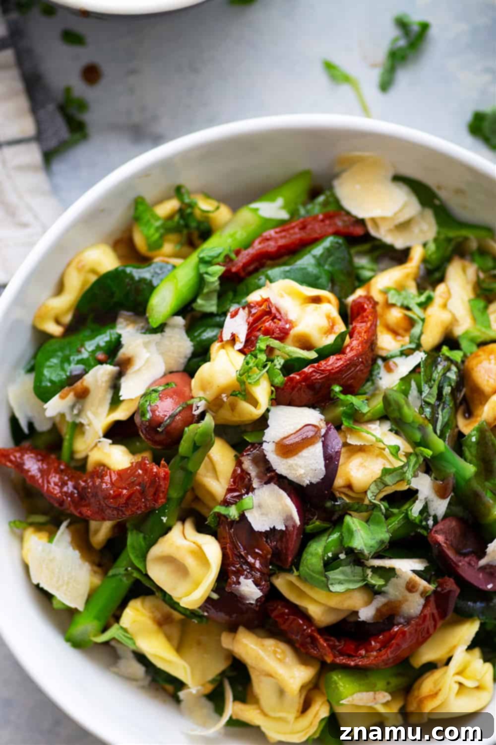 Tuscan Tortellini Salad in a large serving bowl, highlighting the colorful mix of ingredients.
