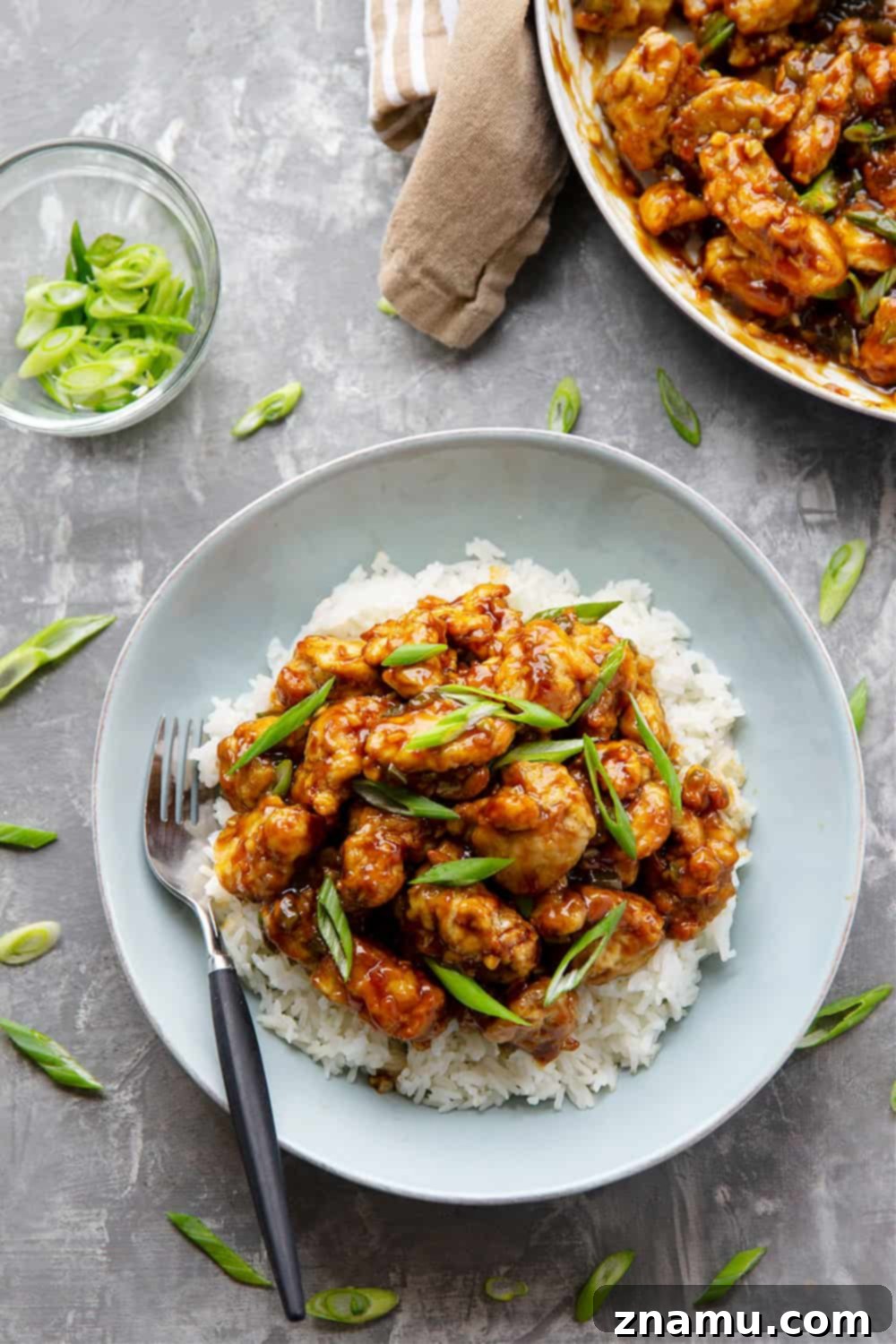 Zesty & Crispy Air Fryer Orange Chicken 2 Crispy Air Fryer Orange Chicken with a vibrant, sticky orange sauce, garnished with green onions and served with fluffy white rice.