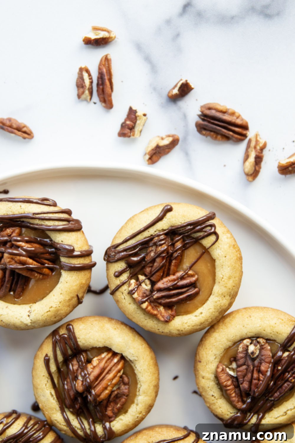 Decadent Turtle Cookie Cups 3 These soft and chewy turtle cookie cups feature a soft butter cookie cup filled with toasted pecans, salted caramel, and a luscious drizzle of melted chocolate.