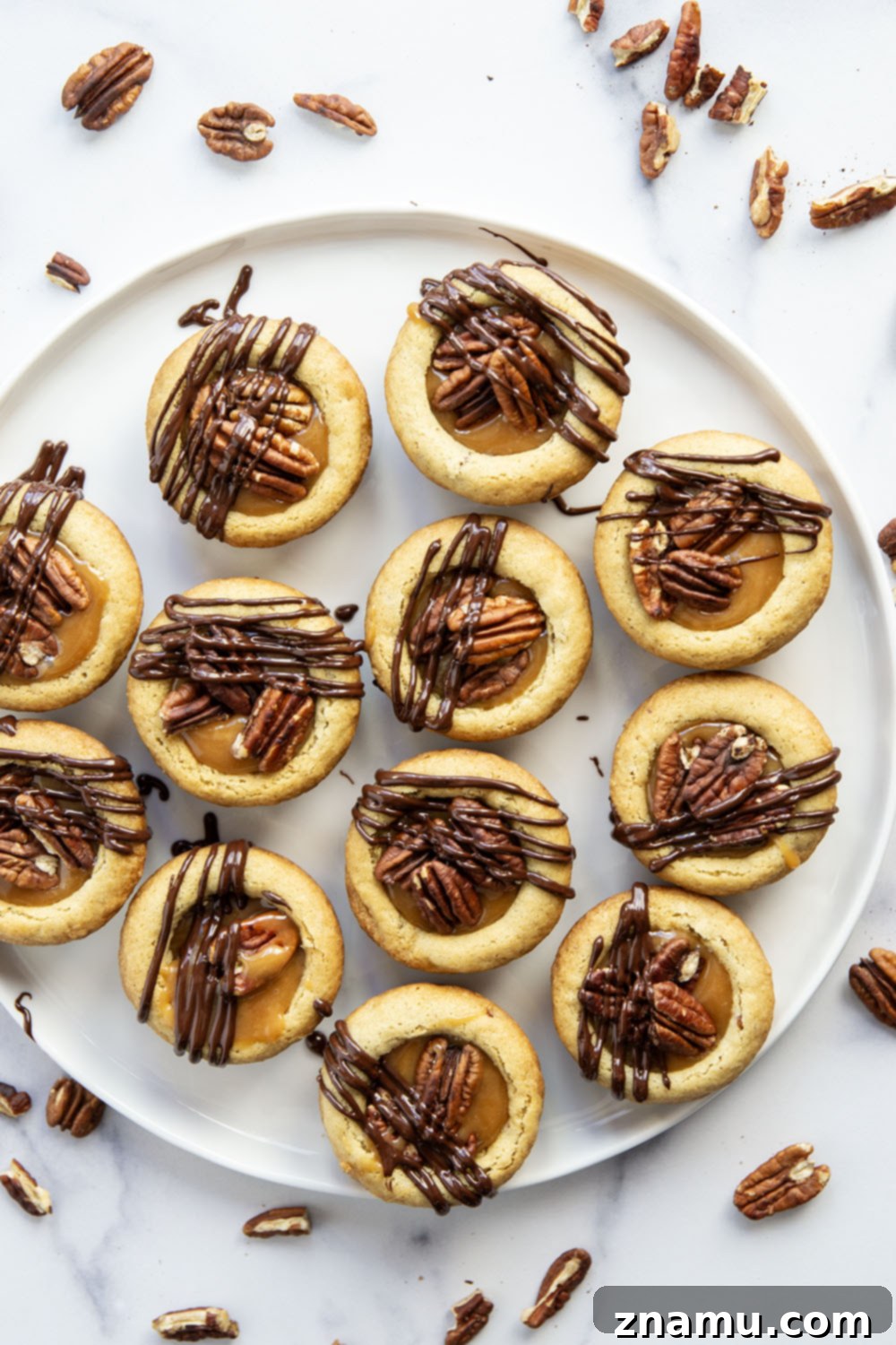 Decadent Turtle Cookie Cups 5 These soft and chewy turtle cookie cups feature a soft butter cookie cup filled with toasted pecans, salted caramel, and a luscious drizzle of melted chocolate.