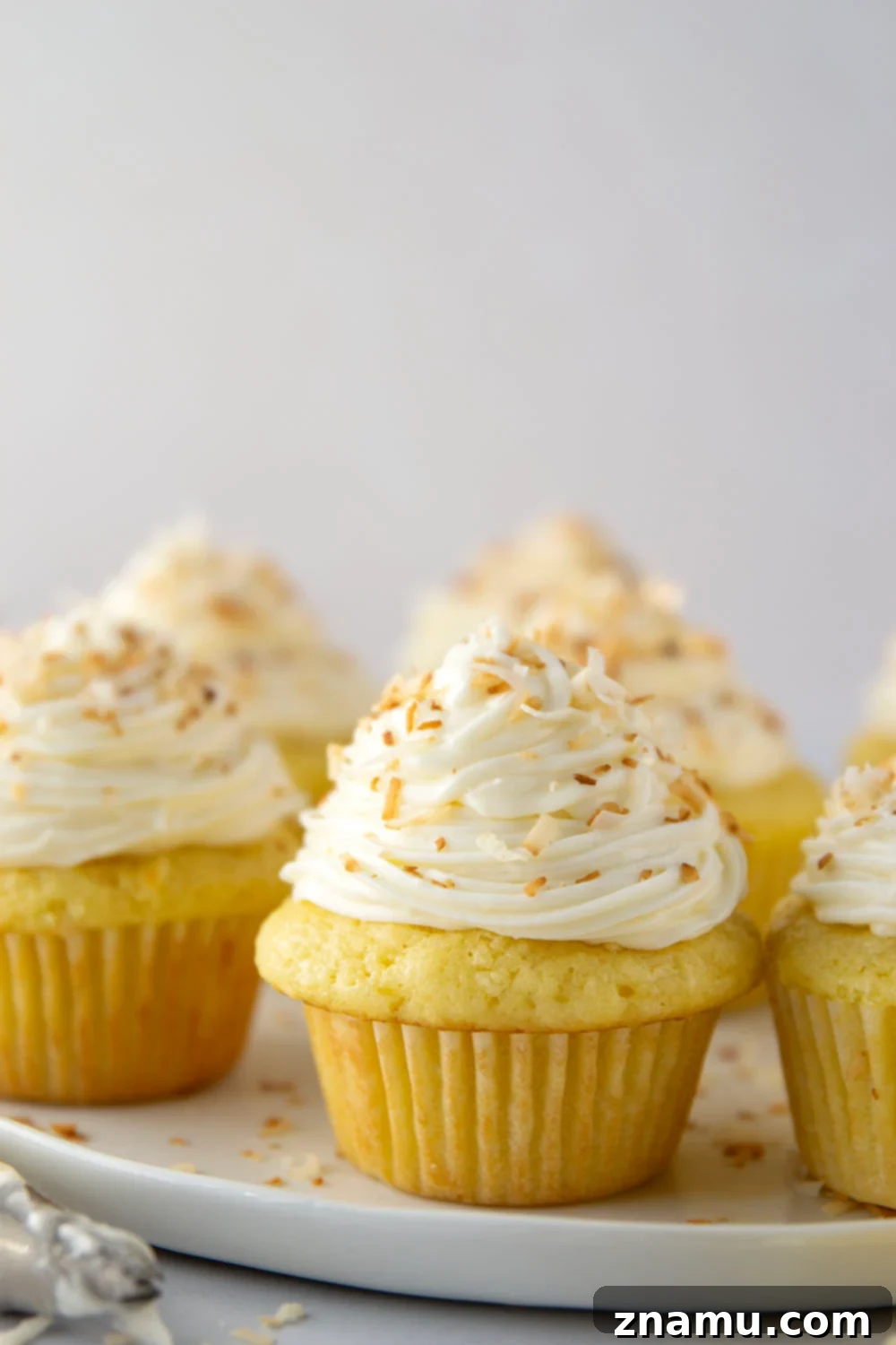 Heavenly Coconut Cupcakes with Cream Cheese Frosting 3 Close-up of a perfectly frosted coconut cupcake ready to be enjoyed